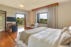 阿瓜斯迪林多亚Villa Boréal Hostellerie的卧室配有一张白色的大床和一张桌子