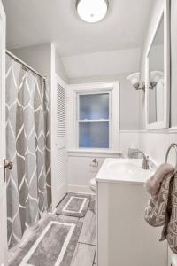 锡拉丘兹Charming Cuse home close to downtown & university的白色的浴室设有水槽和淋浴。