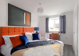 RobyFree Parking Large House Huyton Golf Club M57的一间卧室配有一张带橙色床头板的大床