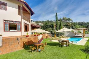 阿瓜斯迪林多亚Villa Boréal Hostellerie的后院设有游泳池、桌子和遮阳伞