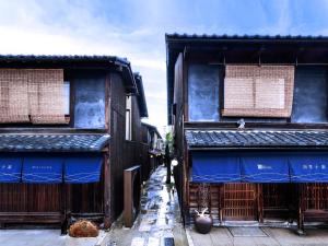 京都Rinn Shiki Juraku的两座建筑之间一条蓝色屋顶的小巷