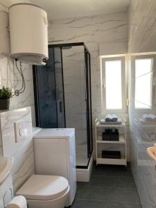 格雷巴蒂卡Sea View Apartments的带淋浴和卫生间的白色浴室