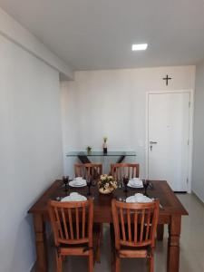 瓜拉派瑞Praia do Morro - Guarapari - Ap 1004 Razões的餐桌、椅子和墙上的十字架