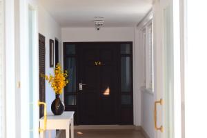 华欣Seapine Beach Golf and Resort Hua Hin的走廊上一扇黑色门,花瓶上花黄色