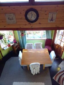 埃尔卡拉法特Casa de Lago y Montaña的一间带桌椅和时钟的用餐室