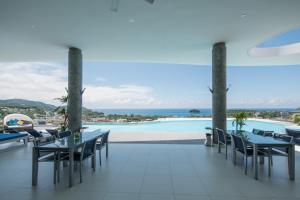 卡塔海滩普吉岛美景公寓式酒店的一个带桌椅的庭院和一个游泳池