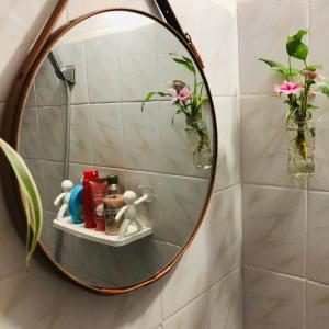 河内Mika Homestay Simple & Cozy的浴室墙上的圆镜子