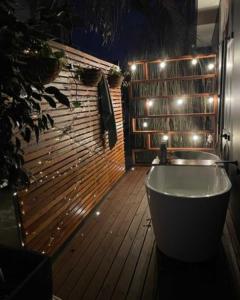 White SandsArk-imedes - Unique float home on the Murray River的带浴缸的浴室以及带灯的木地板