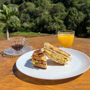 圣安东尼奥-杜皮尼亚尔Espaço Canto的夹三明治和一杯橙汁的白盘