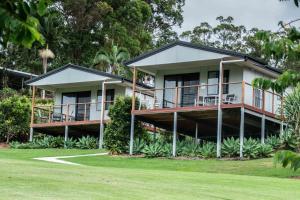 DiddillibahSunshine Coast retreat your own private golf course的带阳台和庭院的房子