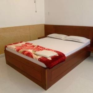 Châu Làng ChánhHotel Thanh Minh的一间卧室配有一张木架大床