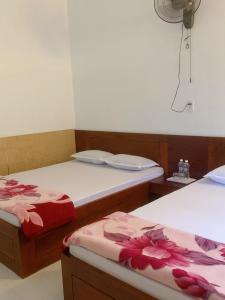 Châu Làng ChánhHotel Thanh Minh的一间设有两张鲜花的床的房间