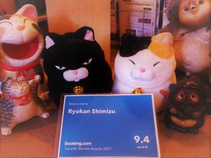 京都清水日式旅馆的一群玩具猫坐在标志旁边