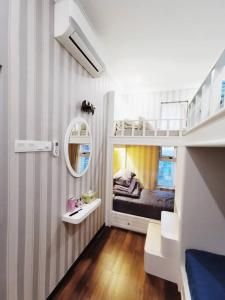 马西English Homestay Seaview Johor Bahru Permas 6 pax的一间小房间,配有双层床和镜子
