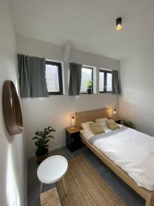 里昂YASI Hostel的一间卧室配有一张床、一张桌子和两个窗户