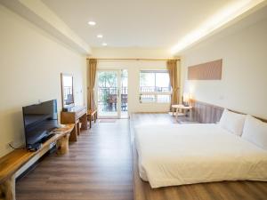Hualing拉拉山云山房的一间卧室配有一张床和一台平面电视