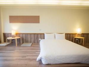 Hualing拉拉山云山房的卧室配有一张白色的大床和两张桌子