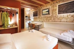 加尔达湖滨阿尔伯格贾尼奥奇达酒店的酒店客房设有两张床和一张桌子。