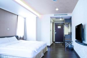埔里埔里西站旅馆的一间卧室配有一张大床和一台平面电视