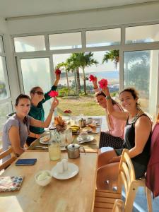 Rodrigues IslandLa Terrasse的一群人坐在桌子上,拿着鲜花