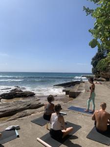 悉尼邦迪海滩村旅舍的一群人在海滩上做瑜伽