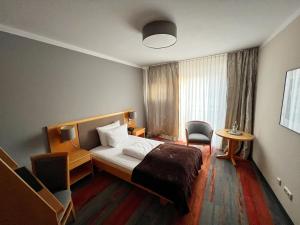 慕尼黑普瑞兹酒店的配有一张床和一把椅子的酒店客房