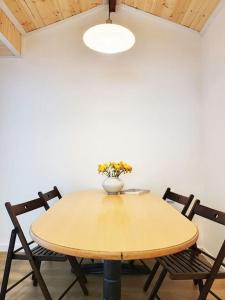 首尔Sam House 2 Seochon的一张桌子,两把椅子,花瓶上放着鲜花