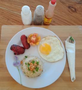 BarasTitaays Surfers Inn的包括鸡蛋和培根的早餐盘