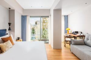雅典The Residence Aiolou Hotel & Spa的一间卧室配有一张床、一张沙发和一个窗口