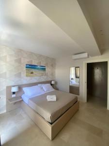 Torre SquillaceB&B La Porta sul Mare a Porto Cesareo的一间白色客房内的床铺卧室