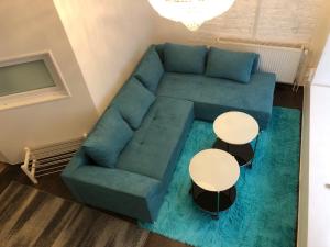 柏林City-Apartment II Kreuzberg的客厅配有蓝色的沙发和2张桌子