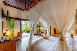 乌布Anumana Village Ubud的一间卧室配有一张带天蓬的床