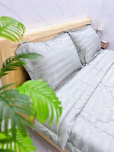 归仁Suri's Homestay的花草旁边的一张带白色床单和枕头的床