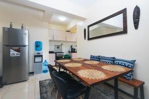 内罗毕Tropical themed 3BR and DSQ Apartment的厨房配有木桌和冰箱。
