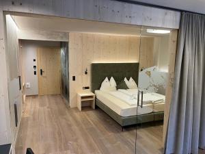 圣瓦伦蒂诺阿拉穆塔柯提斯撇活力别墅酒店的一间卧室设有一张床和玻璃墙