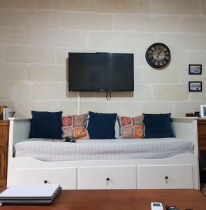 Traditional Maltese House in Birgu的一间卧室,配有一张挂在墙上的时钟床