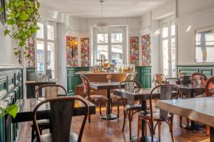 比亚里茨Ama Hôtel的餐厅设有桌椅和窗户。