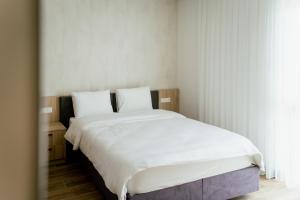 维也纳新城Lamede的一间卧室配有一张带白色床单的大床