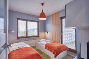 斯维诺乌伊希切Apartamenty Sun & Snow Świnoujście Platan的一间卧室设有两张床和两个窗户。