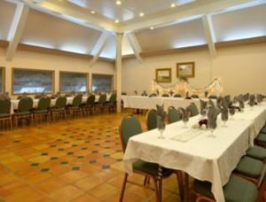 默塞德默塞德套房酒店的宴会厅配有白色桌子和绿色椅子