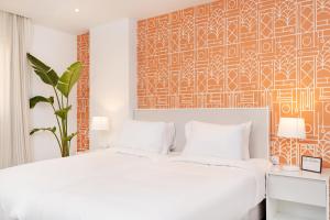 开罗Brassbell apartments by the Pyramids的卧室配有白色的床和橙色及白色的墙壁
