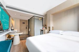 北京后海里院酒店的卧室配有一张白色大床和电视。