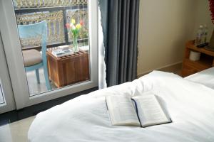 大叻Môn Bạc Home的书坐在带窗户的床上
