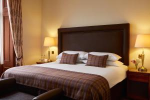 格兰奇茅斯农庄庄园酒店的酒店客房配有一张带枕头的大床
