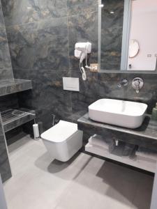 希马拉Anxhelos Hotel的一间带水槽、卫生间和镜子的浴室
