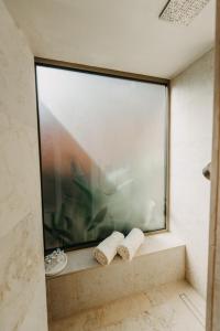 赫瓦尔Zori Timeless Hotel的浴室设有大窗户和2条可移动毛巾。