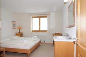 贝特默阿尔卑Ambiente Bettmeralp | A10的白色卧室设有床铺和水槽