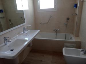 努瓦迪布Hotel Delphin-Nouadhibou的浴室配有两个盥洗盆和浴缸。