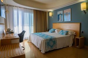 陶尔米纳Taormina Panoramic Hotel的酒店客房设有一张床和一个大窗户
