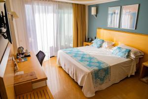 陶尔米纳Taormina Panoramic Hotel的配有一张床和一张书桌的酒店客房